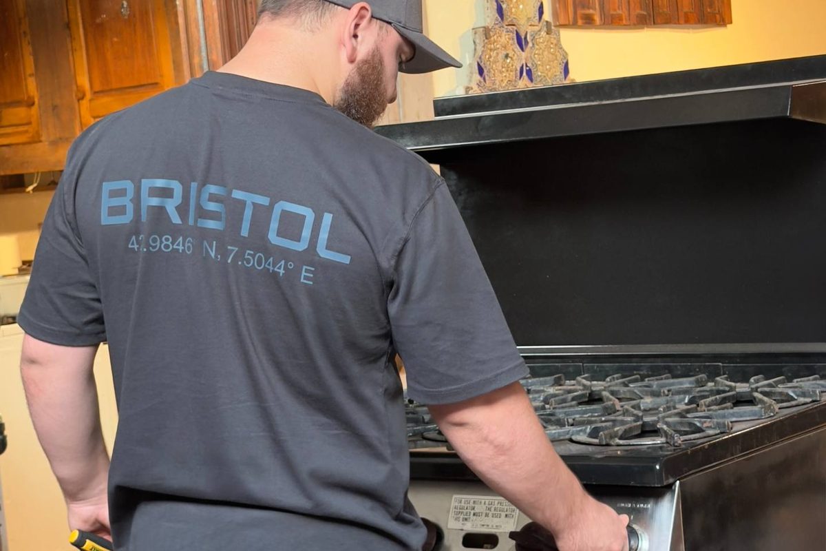 Bristol Appliance Repair technician servicing a professional gas range in Orange County